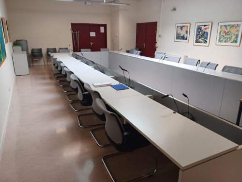 Lokaal M.A.133 heeft vaste tafels en verstelbare stoelen.