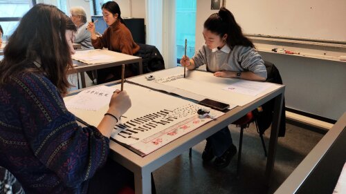 Twee studenten doen aan Chinese kalligrafie
